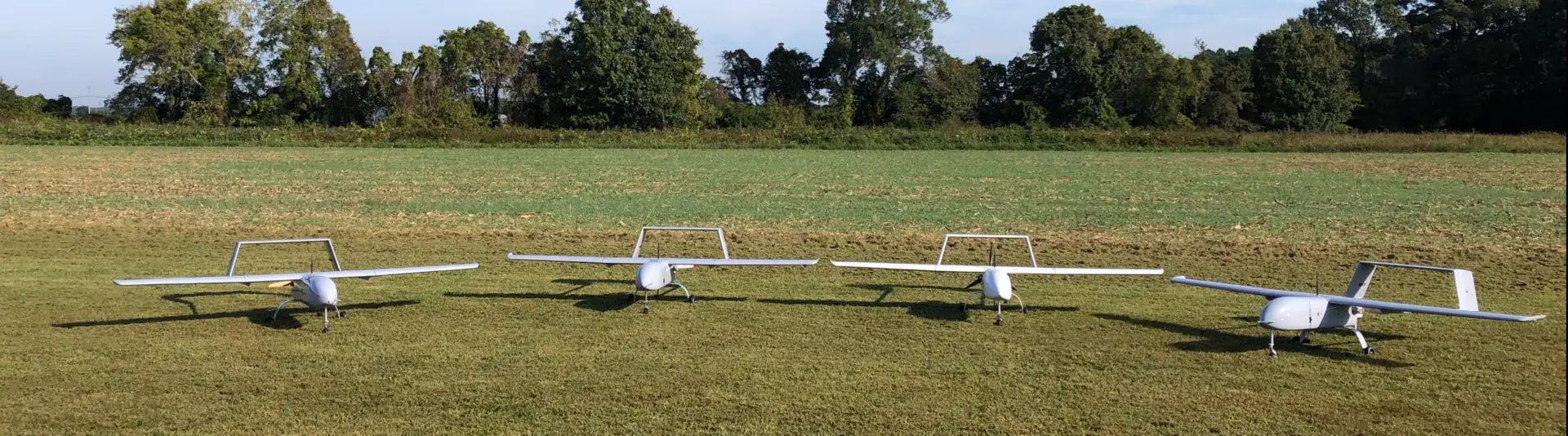four small airplanes on grass